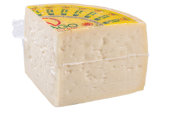 Vacuum-packed pressed cheese block, pale yellow, rectangular with label on top