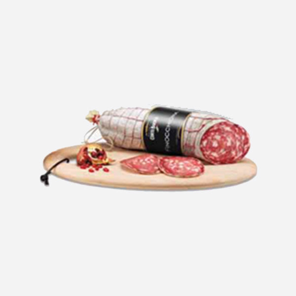 Cylindrical sliced salami with red cured meat and casings, on a wooden board