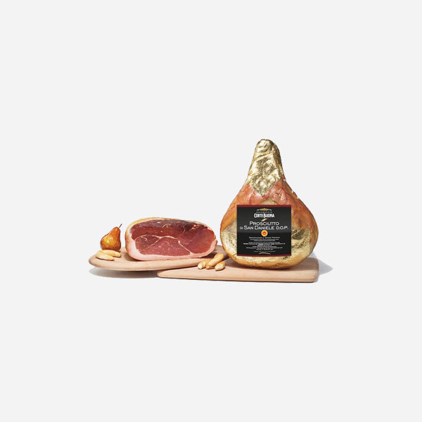 San Daniele prosciutto ham wedge and sliced pieces on wooden board
